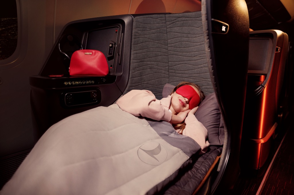 Mujer durmiendo en una cama de gama alta de Turkish Airlines